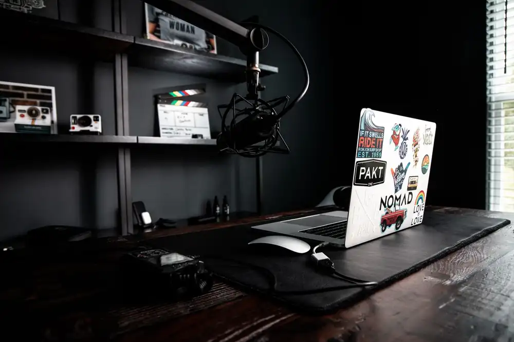 Creative workspace with a laptop and microphone on a desk